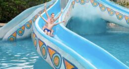 Hotel Xcaret Mexico kids riding down slide at one of the best Riviera Maya Resorts for Familiies