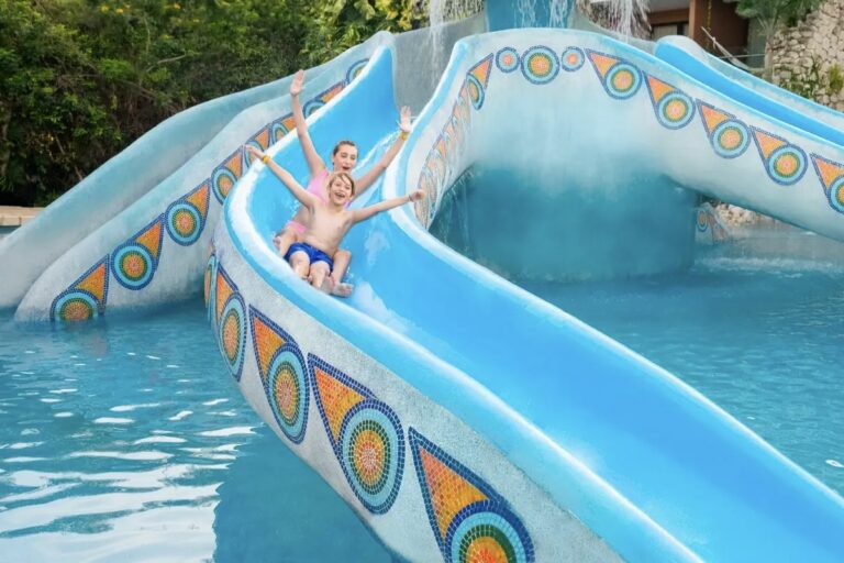 Hotel Xcaret Mexico kids riding down slide at one of the best Riviera Maya Resorts for Familiies